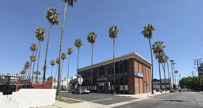 Historic brick building with palm trees near Van Nuys Boulevard